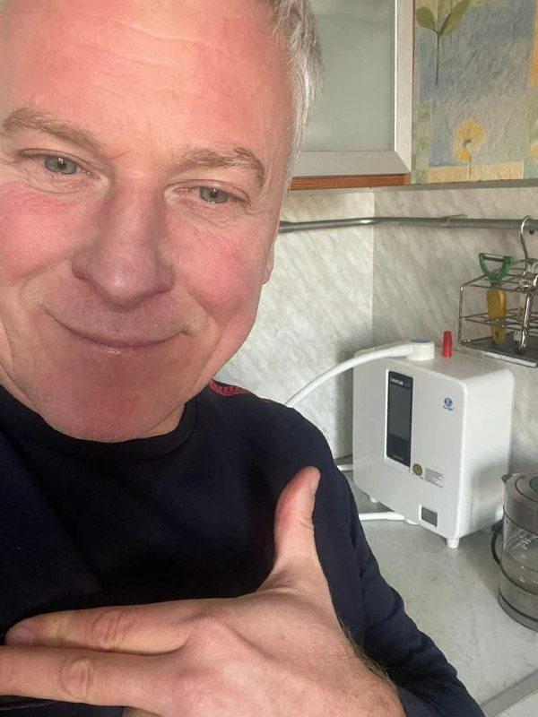 Бронислав Борисович Снетков рядом с аппаратом Kangen Water на домашней кухне